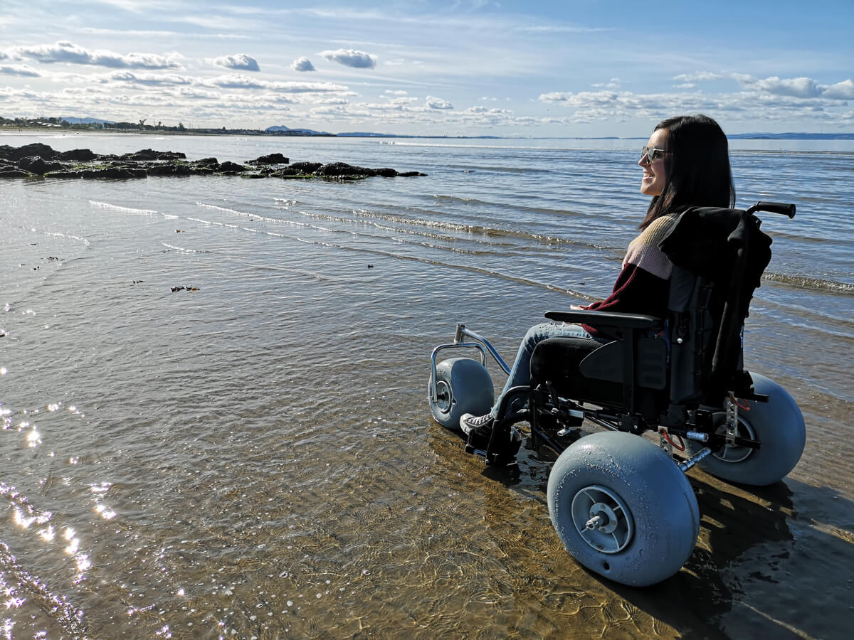 Person using wheelchair conversion kit on the beach